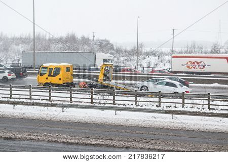 Hemel Hempstead UK - December 10 2017: Roadside assistance truck helps to the broken car on the british motorway M1 during the snowstorm