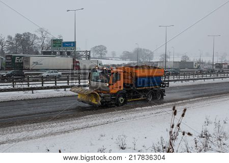 Hemel Hempstead UK - December 10 2017: Snow plough truck spreading salt on the british motorway m1 during snowstorm