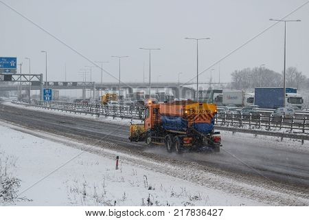 Hemel Hempstead UK - December 10 2017: Snow plough truck spreading salt on the british motorway m1 during snowstorm