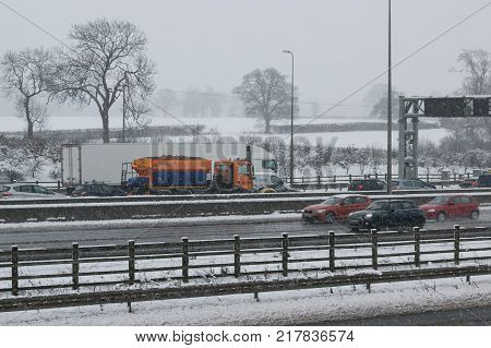 Hemel Hempstead UK - December 10 2017: Snow plough truck spreading salt on the british motorway m1 during snowstorm