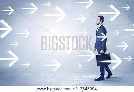 Businessman walking with arrows on the background and briefcase on his hand