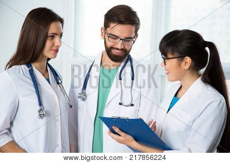 Group of doctors in the clinic discuss the diagnos of the patient
