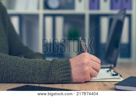Female entrepreneur doing start up business paperwork in home office interior