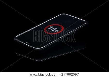 Internet porn addiction. Mobile phone isolated on black background with pornography icon on touchscreen.