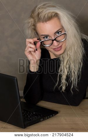 Portrait of a Young Woman in Glasses with a Computer