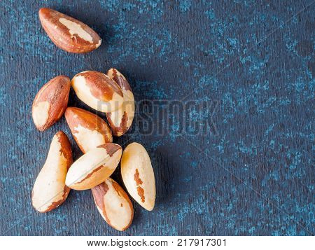 Macadamia nut or brasil nut on dark blue background with copy space Top view or flat-lay.