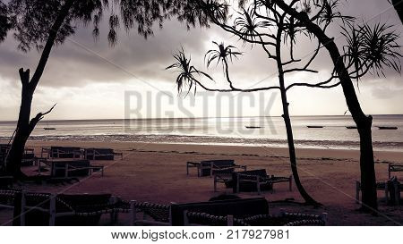 Beach with sun loungers and a place for rest at sunset.