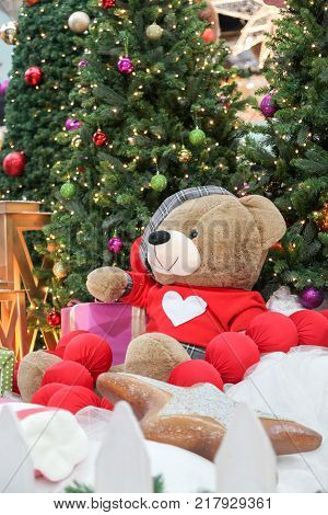 Big Teddy Bear Near A New Year Tree And Gifts