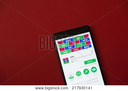 Los Angeles, december 11, 2017: Smartphone with Rar application in google play store on red background