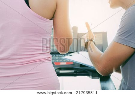 asian young female slim body on machine treadmill with young man personal trainer giving thumbs up in fitness gym bodybuilder healthy lifestyle exercise fitness workout and sport training concept