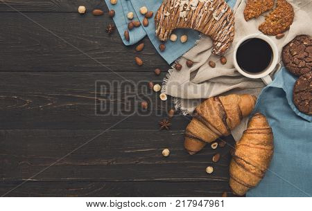 French croissants and coffee background. Tasty french breakfast with variety of homemade cookies, nuts and buns. Mockup for sweet pasrty recipe, top view, copy space