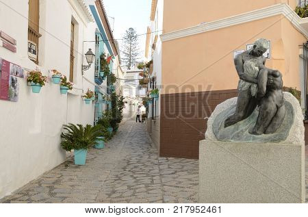 ESTEPONA, SPAIN - DECEMBER 6, 2017: Bronze sculpture of man and woman in streets of the old town of Estepona Malaga Andalusia Spain.