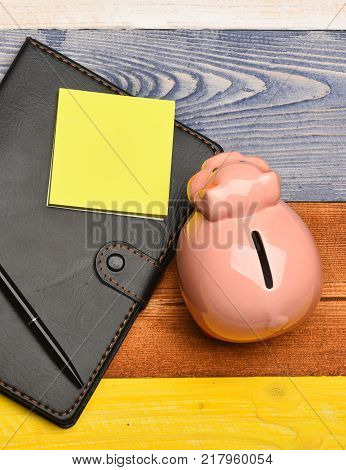 Moneybox With Pig Face Near Organizer And Pen.