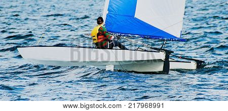 Young female High School student sailing racing a catamaran in the Australian championships at Lake Mac quarie Australia.