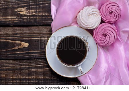 Delicate zephyr with flavored coffee on wooden and pink backgrounds