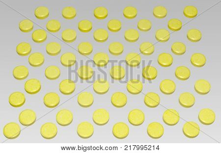 many yellow pills are arranged by chequerwise