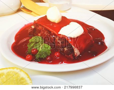 A fresh slice of cherry pie with cherry jam on a white plate. Close up shot