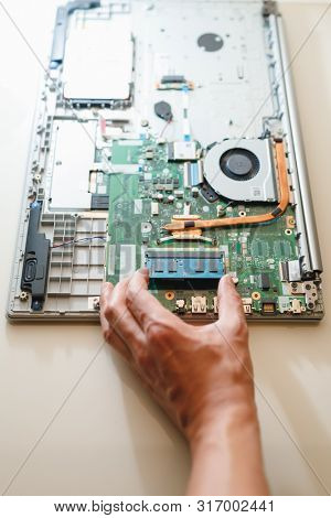 hand of repairman holding a ram sodimm memory module, laptop upgrade 