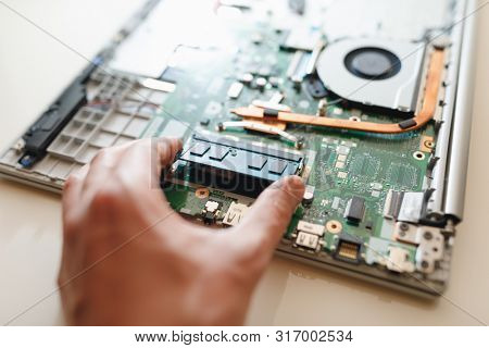 hand of repairman holding a ram sodimm memory module, laptop upgrade 