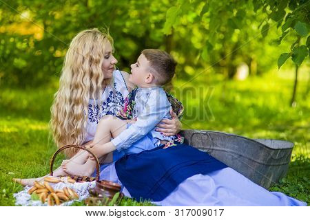 Portrait Of Happy Caucasian Mother With Her Little Kid. Posing With Basket Full Of Bread Rings Outdo