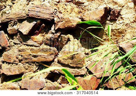 Ancient Stone Wall Near The River Near The Reeds