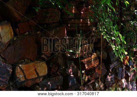 Old Wall Made Of Large Stones Of Iron Ore Bonded By Sand.