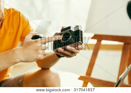 Young Caucasian Male Blogger With Professional Equipment Recording Video Review Of Camera At Home. B