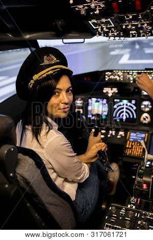 Female Pilot The Captain Of The Plane Prepares For Take-off In The Plane Cockpit.