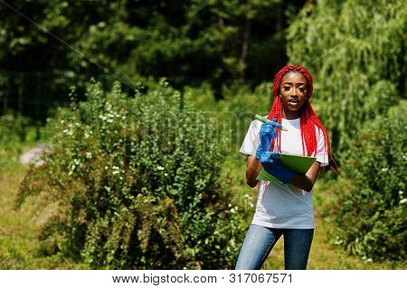 African Red Haired Volunteer Woman With Clipboard In Park. Africa Volunteering, Charity, People And