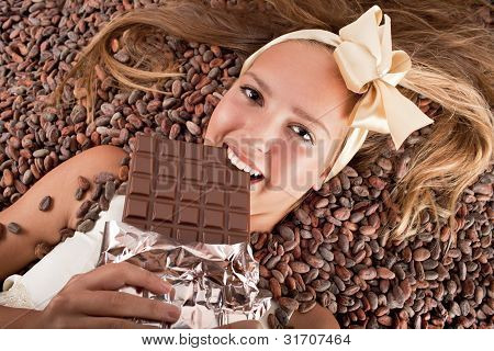 Smuk pige med chokolade på kakaobønner