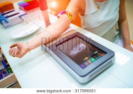 Young Woman Finding Veins With Vein Scanner Device For Injection In A Medical Laboratory