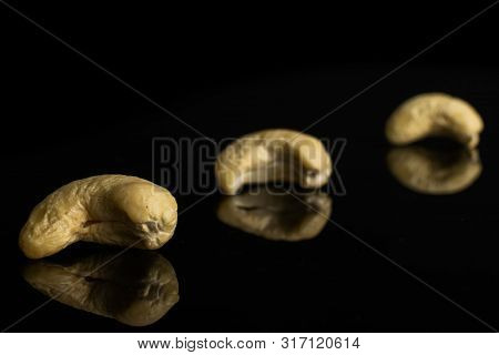 Group Of Three Whole Unsalted Beige Cashew Isolated On Black Glass
