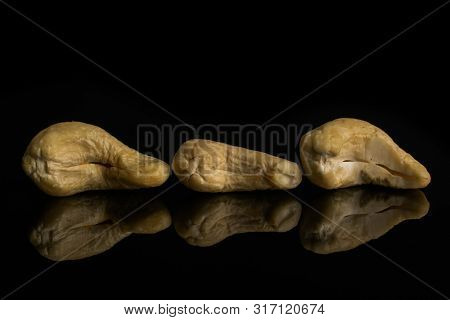 Group Of Three Whole Unsalted Beige Cashew Isolated On Black Glass