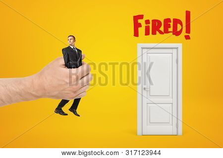 Big Male Hand Bringing Tiny Businessman To White Doorway With Red Fired Sign On Yellow Background
