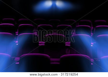 Empty Movie Theater With Purple Seats With Flare Light Rays From Projector