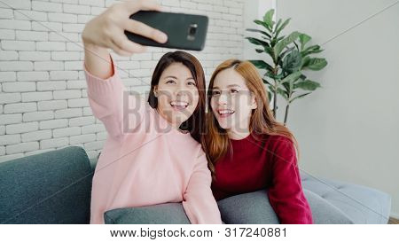 Lesbian Asian Couple Using Smartphone Selfie In Living Room At Home, Sweet Couple Enjoy Funny Moment