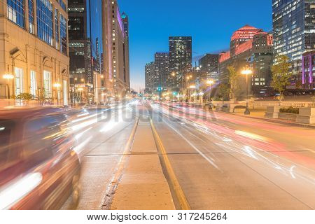 Wacker Dr Street With Tall Buildings And Street Light Trails In Chicago At Night