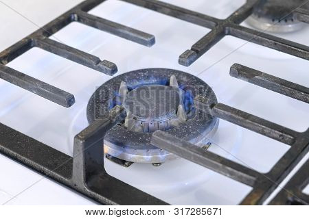 Self-igniting Big Gas Berner Turning On The Cooktop Gas Sove. Gas Stove With Lattice. Close-up View.