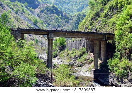 North Korea. Local Road Between Rocks In Ulim Mountains. Bridge Over A Mountain Stream