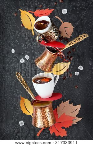 Balancing Pyramid Of Jezves, Turkish Coffee Pots And Cups On Dark Background With Coffee Beans And S
