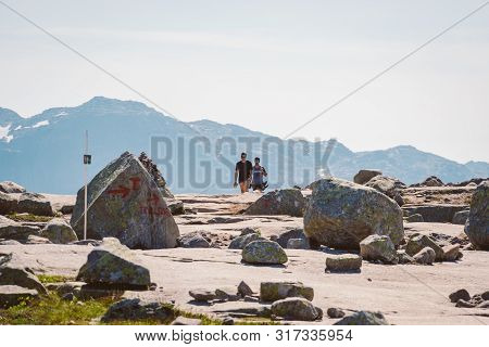July 26, 2019. Norway Tourist Route On The Trolltunga. People Tourists Go Hiking In The Mountains Of