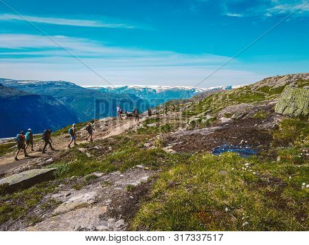 July 26, 2019. Norway Tourist Route On The Trolltunga. People Tourists Go Hiking In The Mountains Of
