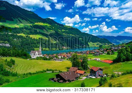 Catholic Church, Traditional Wood And Modern Houses Along The Lake Lungernsee In Swiss Village Lunge