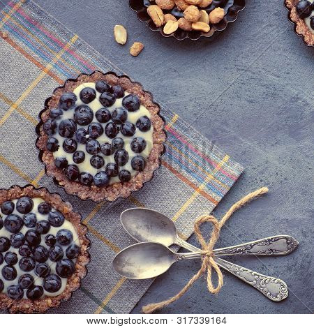 Top View On Wholegrain Blueberry Tarts With Vanilla Cream On Dark Background