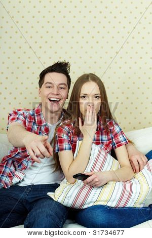 ภาพเหมือนของคู่รักหนุ่มสาวระหว่างดูทีวี