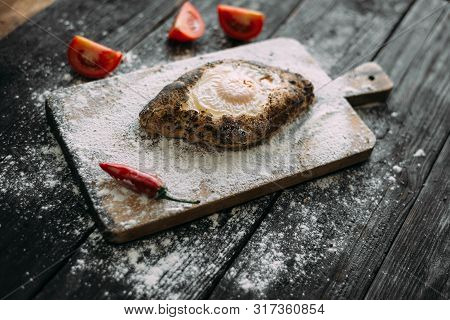 Adjarian Khachapuri Is A Traditional Georgian Cheese Dough With Eggs On A Cutting Board.