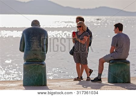 Zadar, Croatia - April 29, 2018: People Chilling By The Spiridon Brusina Monument At Promenade Obala