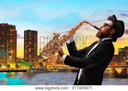 Man playing a saxophone with a view of a city as a background