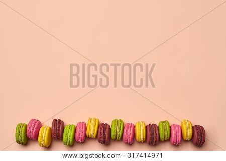Colored Macaron Or Macaroon, Sweet Meringue-based Confection On Pink Background. Close-up, Copy Spac