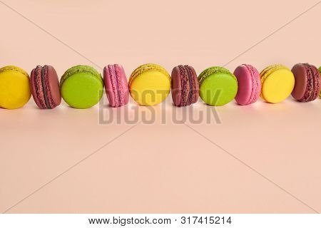 Colored Macaron Or Macaroon, Sweet Meringue-based Confection On Pink Background. Close-up, Copy Spac